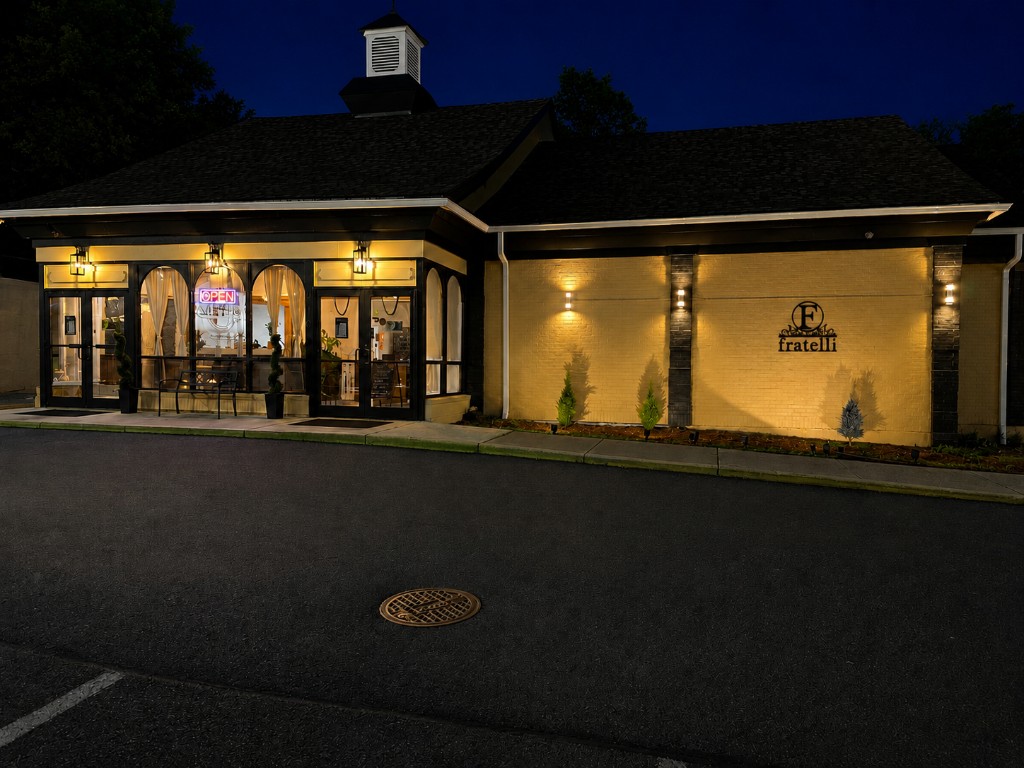 Fratelli restaurant at night in Alexandria, VA — inviting entrance, warm lighting, and family-owned Italian fine dining